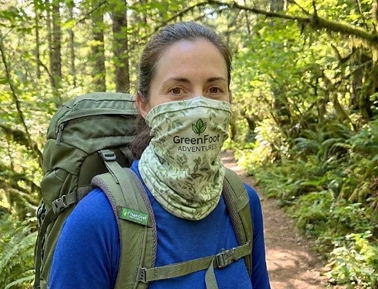 A woman wearing a custom neck neck tube made of RPET material while hiking.